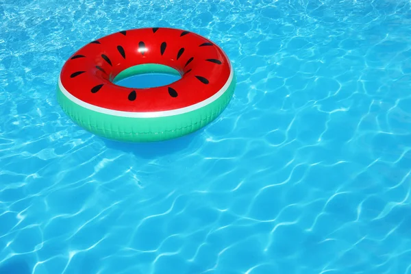 Inflatable ring floating in swimming pool on sunny day. Space for text