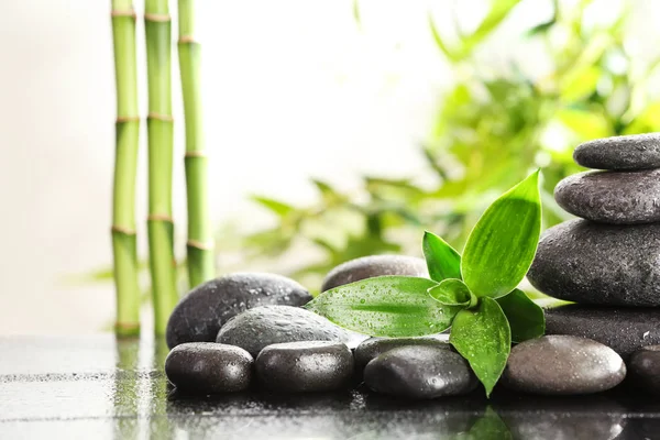 Bambusblätter Mit Wellness Steinen Auf Dem Tisch Vor Verschwommenem Hintergrund — Stockfoto