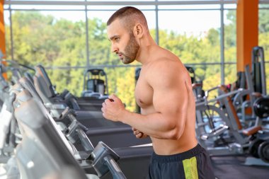 Spor salonunda halter kaldırma güçlü genç adam