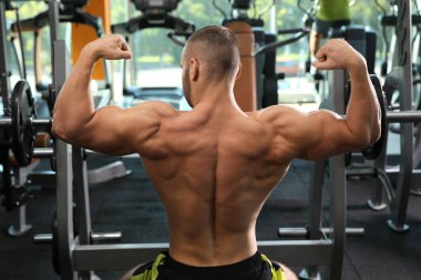 Spor salonunda halter kaldırma güçlü genç adam