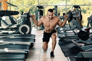 Spor salonunda halter kaldırma güçlü genç adam