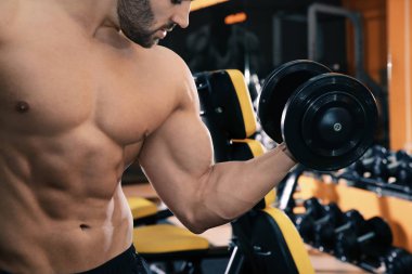 Spor salonunda halter kaldırma güçlü genç adam