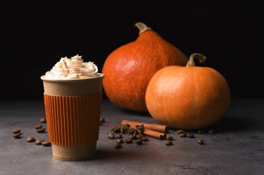 Paper cup with tasty pumpkin spice latte on gray table clipart
