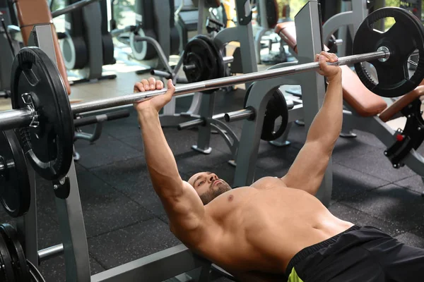 Fuerte Joven Levantando Barra Gimnasio —  Fotos de Stock