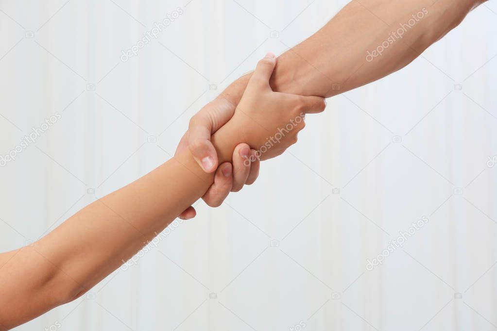 People holding hands together on light background. Concept of support and help