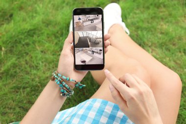 Cctv kameraları açık havada izlemek için Smartphone kullanan adam. Ev güvenlik sistemi