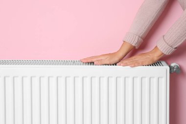 Eller ısınma kadın radyatör renk duvarının yakınında Isıtma