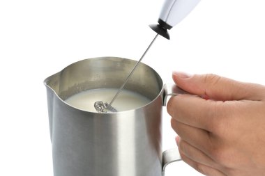 Beyaz arka planda, closeup sürahi içinde süt frother aygıt kullanan kadın