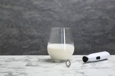 Süt frother aygıt ve cam gri duvar karşı masada