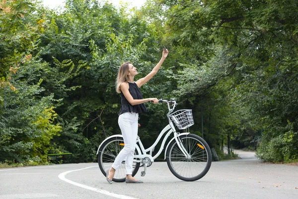 Atrakcyjna Kobieta Biorąc Selfie Pobliżu Rower Zewnątrz — Zdjęcie stockowe
