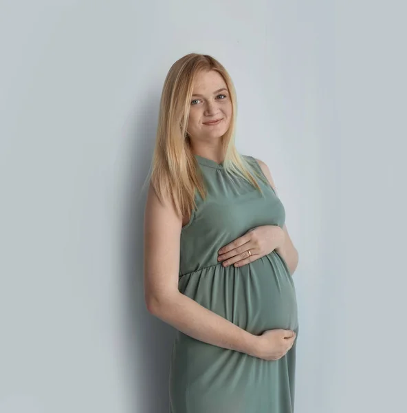 Молодая Беременная Женщина Трогает Живот Светлом Фоне — стоковое фото