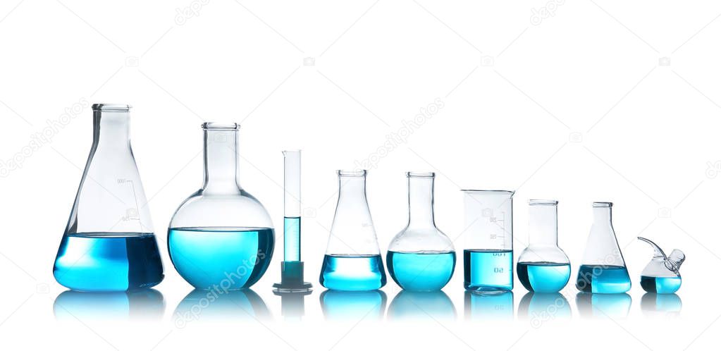 Laboratory glassware for chemical analysis with blue liquid on table against white background