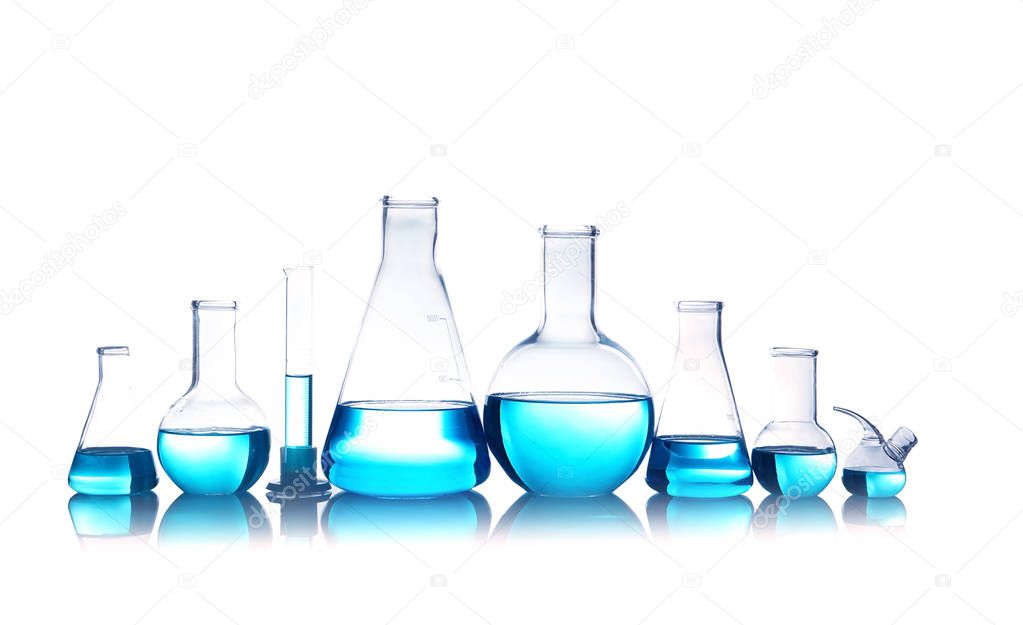 Laboratory glassware for chemical analysis with blue liquid on table against white background