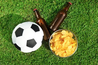 Futbol topuyla içecekler ve cips yeşil futbol alan çimen, düz üzerinde yatıyordu