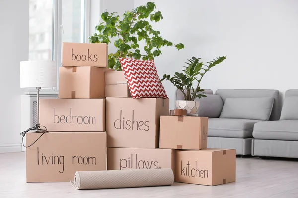 Pile of moving boxes and household stuff in living room