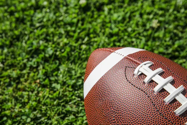 新鮮な緑の野原の草のアメリカン フットボールのボール — ストック写真