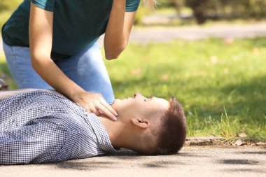 Passersby helping unconscious man outdoors. First aid clipart