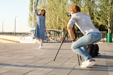 Genç kadın fotoğrafçı alarak fotoğraf ile Park profesyonel fotoğraf makinesi. Metin için yer