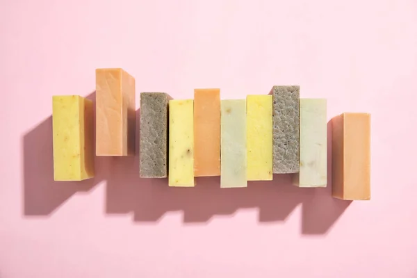 Hand made soap bars on color background, top view