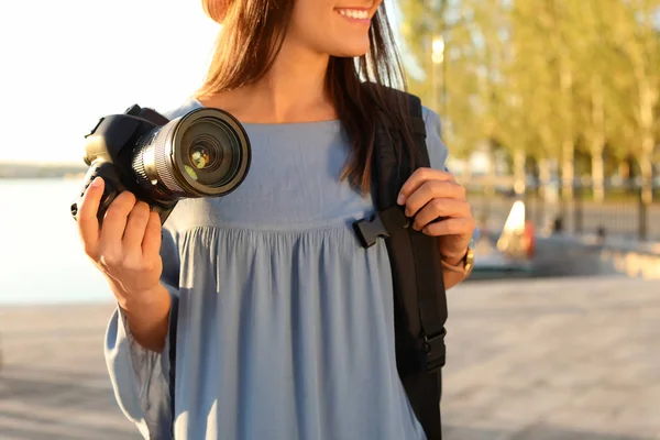 年轻的女摄影师持有专业相机在码头 — 图库照片