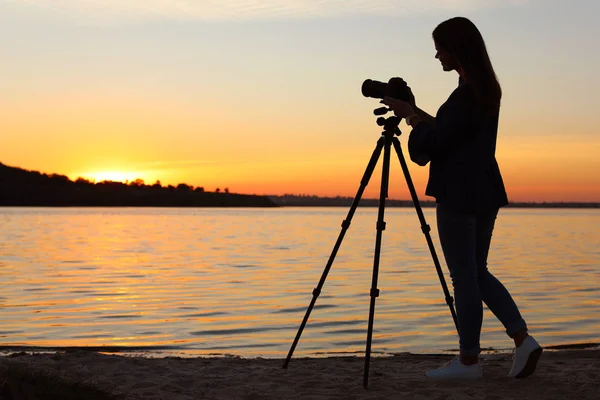 Junge Fotografin Justiert Professionelle Kamera Auf Stativ Bei Sonnenuntergang — Stockfoto