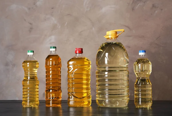 Ölflaschen Auf Dem Tisch Vor Farbigem Hintergrund — Stockfoto