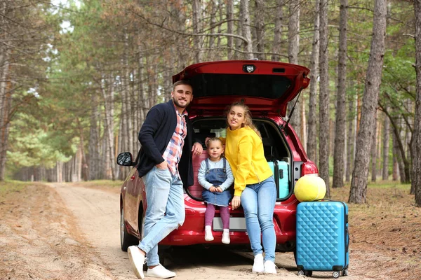 車のトランクに近い幸せな若い家族が屋外のスーツケースを搭載 — ストック写真