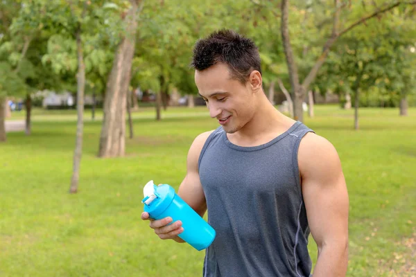 Young man drinking protein shake on street