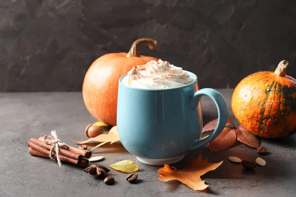 Cup with pumpkin spice latte on gray table