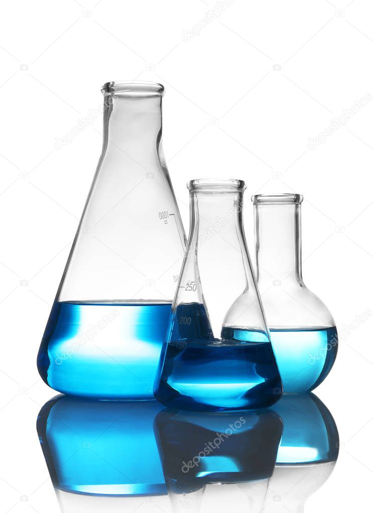 Laboratory glassware with liquid on table against white background. Chemical analysis