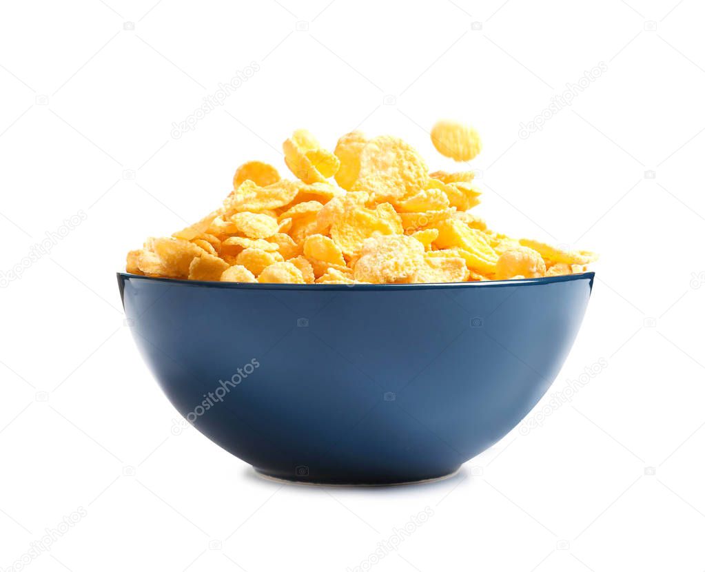 Crispy cornflakes falling into bowl on white background