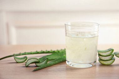 Ahşap masa metin için yer ile ışık arka plan cam aloe vera suyu ve yeşil yaprak