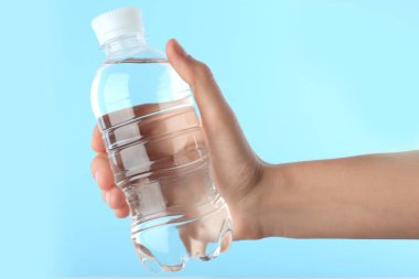 Plastik şişe ile su renk arka plan üzerinde tutan kadın