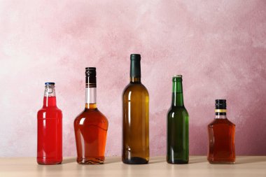Tablo renkli arka plan üzerinde farklı alkollü içecekler şişe