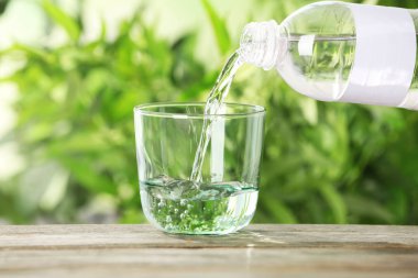 Şişe cam arka plan bulanık karşı masada içine su dökme