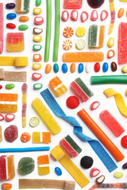 Beyaz zemin üzerine lezzetli renkli şekerler ile düz yatıyordu kompozisyon