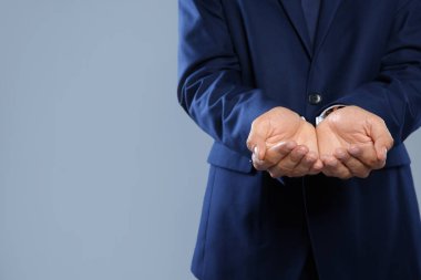 Bir şey gri arka plan, metin için yer ile el görünümünü portre üzerinde tutan işadamı