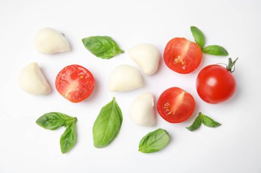 Taze yeşil fesleğen yaprağı, kiraz domates ve mozzarella beyaz arka planda, üstten görünüm