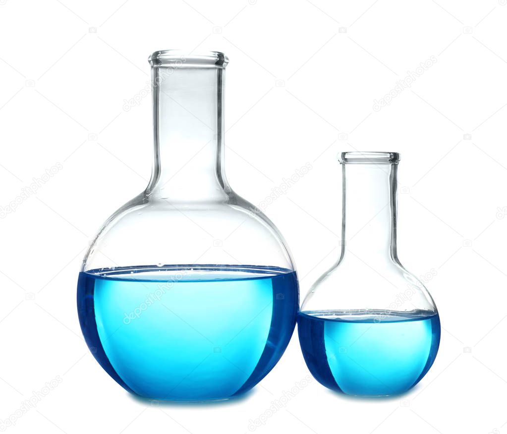 Flasks with blue liquid on table against white background. Laboratory analysis