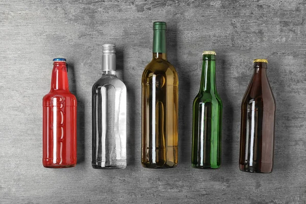 Flaskor Med Olika Alkoholhaltiga Drycker Grå Bakgrund Ovanifrån — Stockfoto
