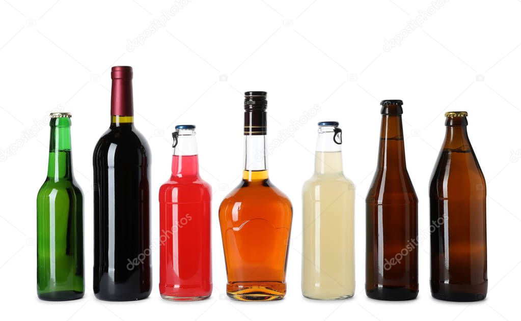 Bottles with different alcoholic drinks on white background