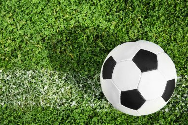 Yeşil futbol sahası çimlerinde futbol topu, üst manzara. Metin için boşluk