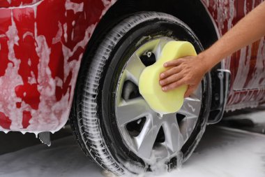 Adam araba yıkamada, closeup sünger ile kırmızı oto yıkama