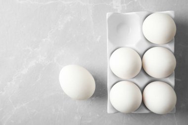 Açık renkli, üstten görünüm üzerinde seramik tutucu çiğ tavuk yumurtası. Metin için yer