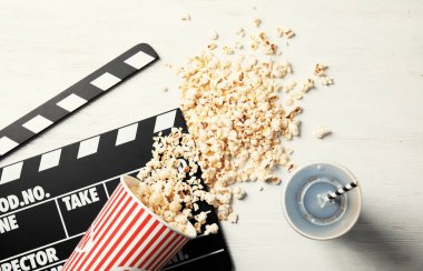 Lezzetli patlamış mısır, içki ve Klaket ahşap arka plan, üstten görünüm üzerinde. Sinema snack
