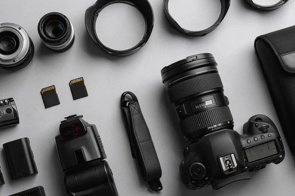Flat lay composition with professional photographer equipment on light background