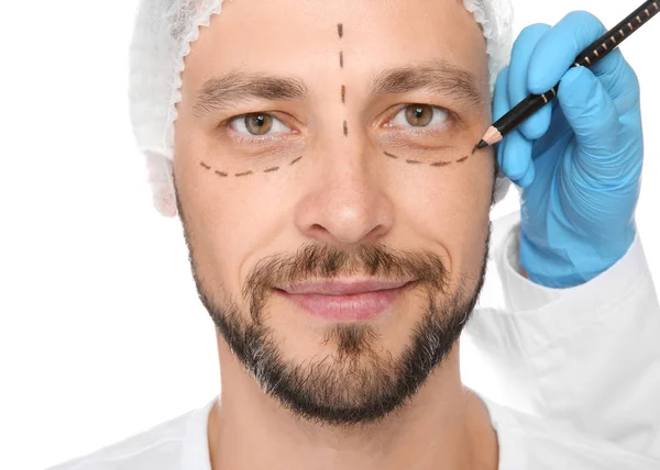 白い背景の整形手術の前に中年の男性の顔をマーキング医師 — ストック写真