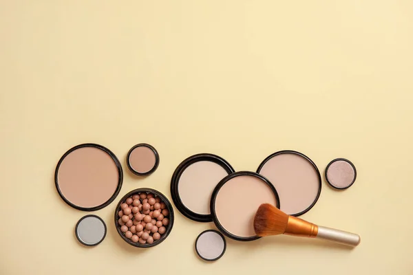 Flat lay composition with various makeup face powders on color background. Space for text