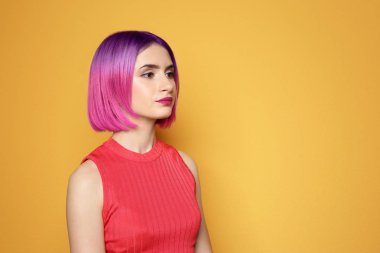 Portrait of young woman with dyed short straight hair and space for text on yellow background. Trendy hairstyle design 
