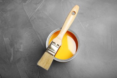 Sarı boya ve fırça gri arka planda, üstten görünüm ile yapabilirsiniz